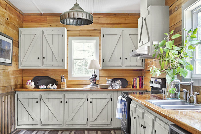 modele de cuisine bois et blanc avec revetement mural bois clair, meubles hauts et bas à portes placard blanc vintage, tapis gris et blanc, aspirateur inox