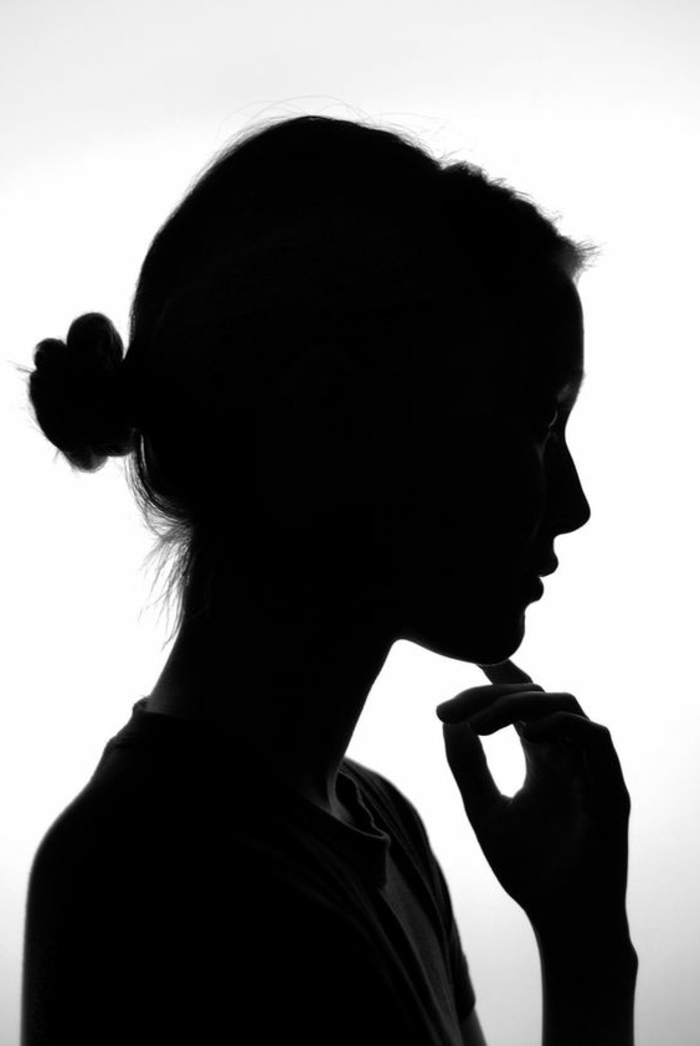 photo femme noir et blanc, jeune femme pensive, chignon chic, belle silhouette fine, photo sans décor, juste une jolie silhouette 