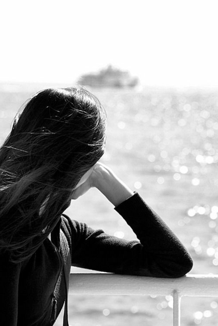 photos noir et blanc, jeune femme contemplant la mer, bateau à l'horizon, journée d'été, reflets de lumière sur la surface de l'eau 