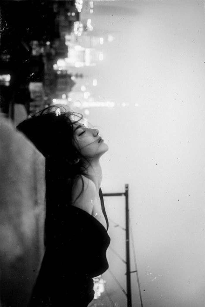 photo femme noir et blanc, asiatique prise en photo sur le fond de la grande ville avec ses formes et lumières, paysage urbain