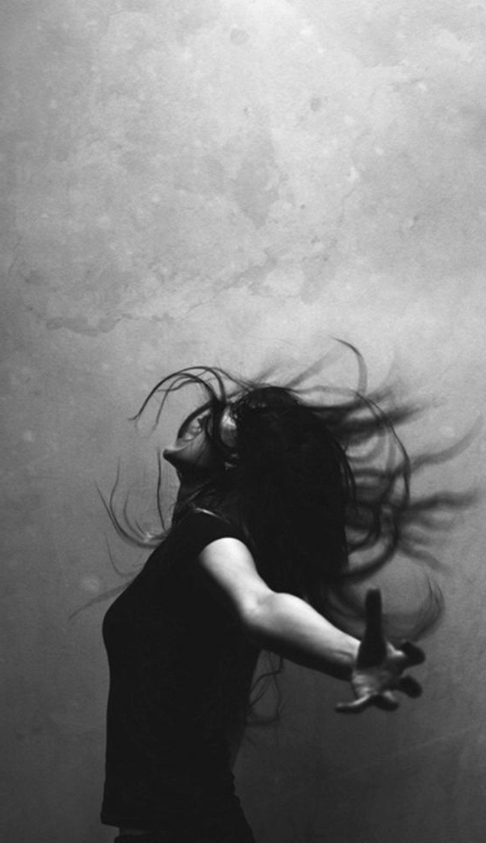 portrait noir et blanc, femme qui laisse s'échapper les émotions, hurle et se penche a l'arrière, cheveux longs, mouvement de la crinière en arrière