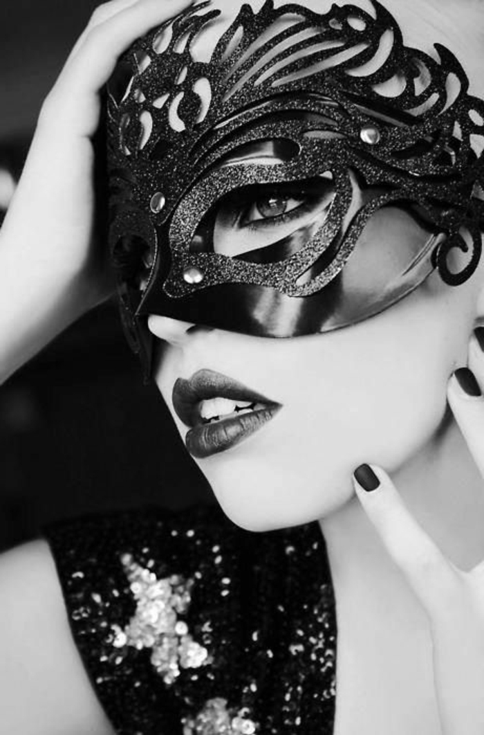 photo en noir et blanc, femme avec un masque de type vénitien, pendant une grande fête, maquillage sexy, robe en paillettes brillantes 