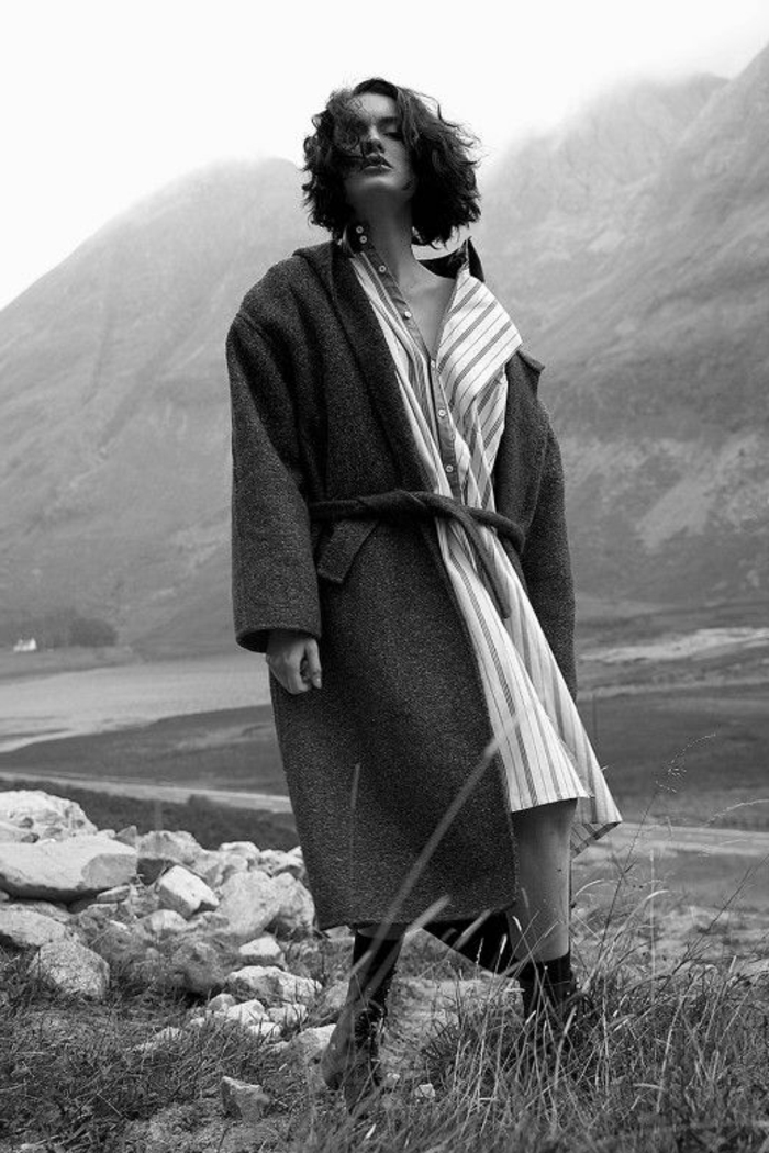 photo femme noir et blanc, manteau avec ceinture, paysage montagneux, des roches, promenade dans la montagne, fille cool avec coiffure au carré 