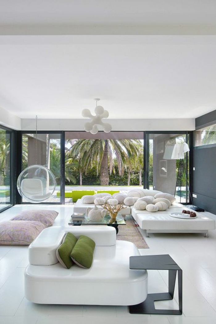 deco salon design avec des meubles en blanc et corps luminaire en blanc, sol brillant en blanc, deux coussins de sol en rose pastel