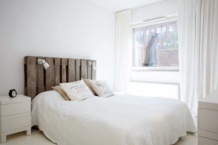 tete de lit palette, chambre blanche avec grande fenêtre et murs longs et blancs décorée en style minimaliste
