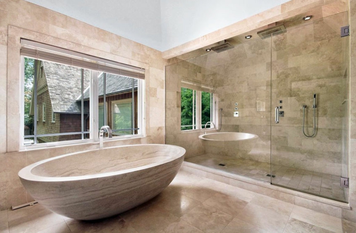 salle de bain luxueuse, baignoire travertin, grande fenêtre, miroir mural et cabine de douche