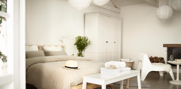 garde-robe blanche dans chambre a coucher adulte au plafond de bois, déco cocooning avec cheminée et plante verte