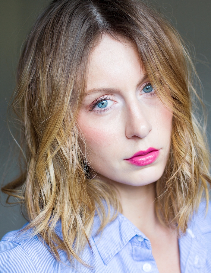 carré-plongeant-bouclé-avec-des-ondulations-légères-chemise-femme-bleu-clair-rouge-a-levres-rose-effet-coiffé-décoiffé carré plongeant long avec des ondulations fines, coiffure de tous les jours pour une femme aux cheveux blond foncé