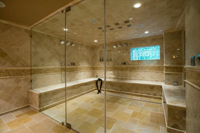 pierre travertin, salle d'eau en beige, douches pluie au plafond, portes en verre, 