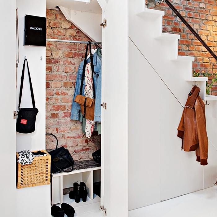 déco industriel aux murs briques avec meuble chaussure sous escalier à design minimaliste blanc