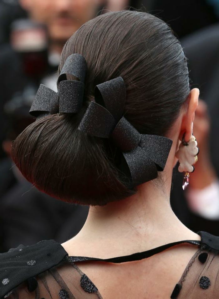 grands boucles d'oreille, accessoires noirs dans les cheveux, chignon bas, coiffure demoiselle d'honneur