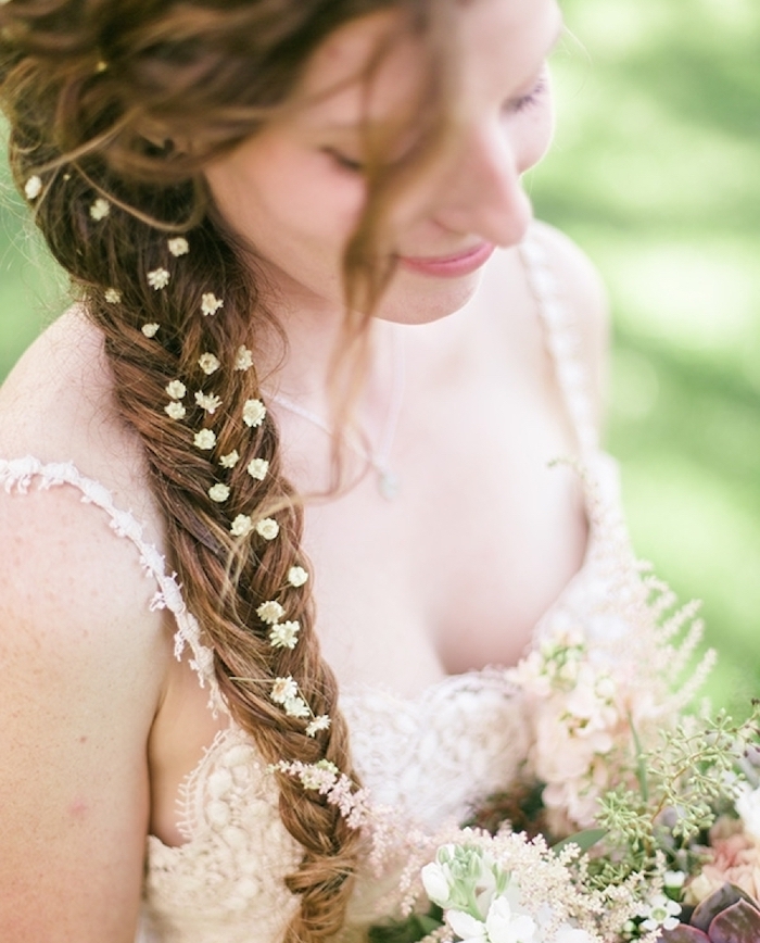 modele de coiffure tresse épi sur le coté style boheme chic avec des mèches rebelles et petites fleurs dans les cheveux, robe de mariée champêtre