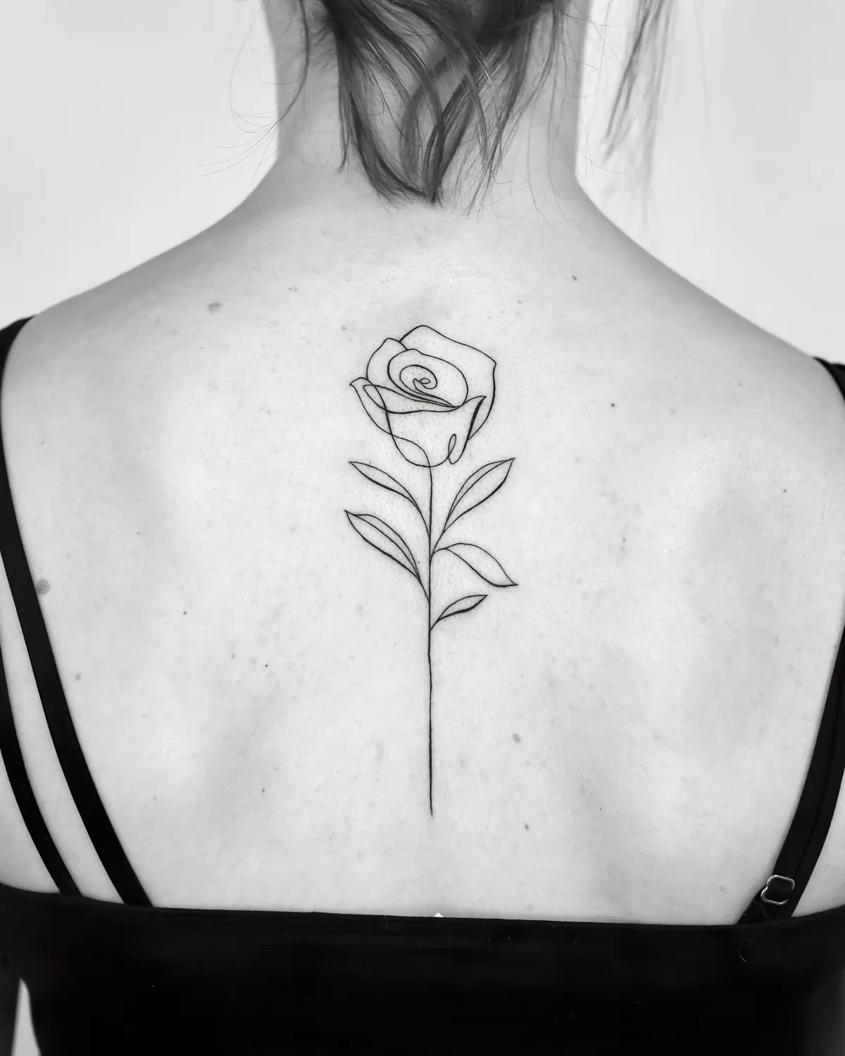 dessin en forme de rose sur le dos tatouage pour femme