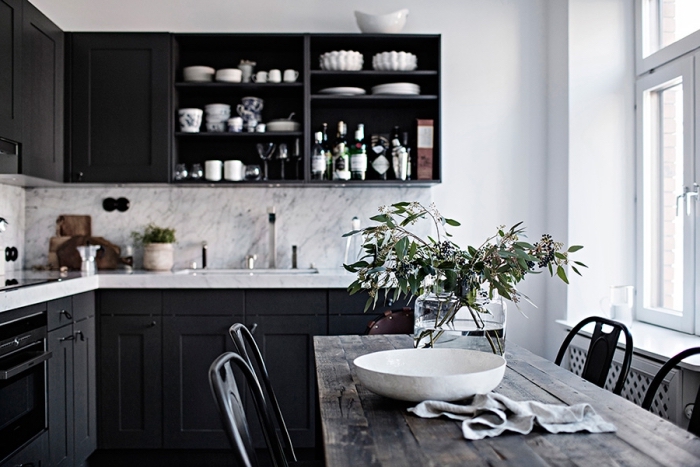 intérieur moderne et traditionnel avec armoires noires et crédence à design marbre gris et blanc dans une cuisine aménagée