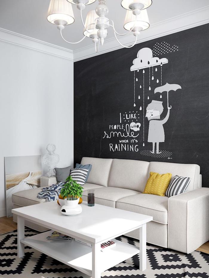 exemple de déco salon avec mur de fond en peinture craie, canapé blanc cassé, table basse blanche et tapis noir et blanc, lustre élégant
