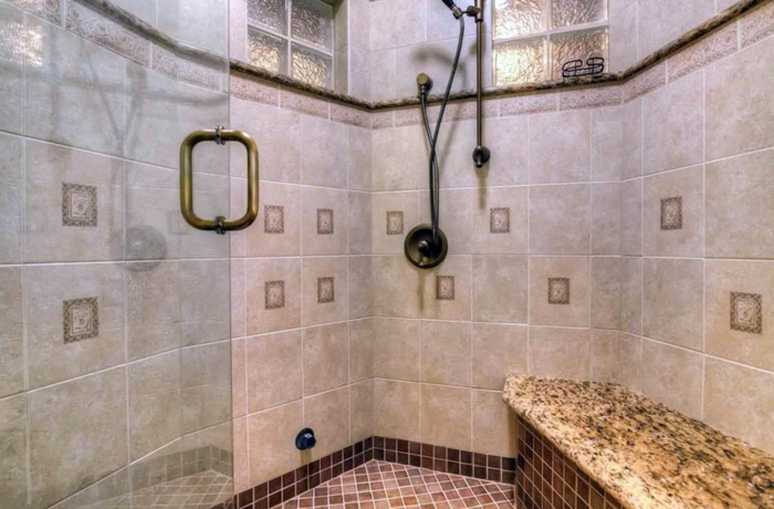 installer un banc en pierre dans la salle de bains, parois en verre, sol en petites tuiles mosaiques