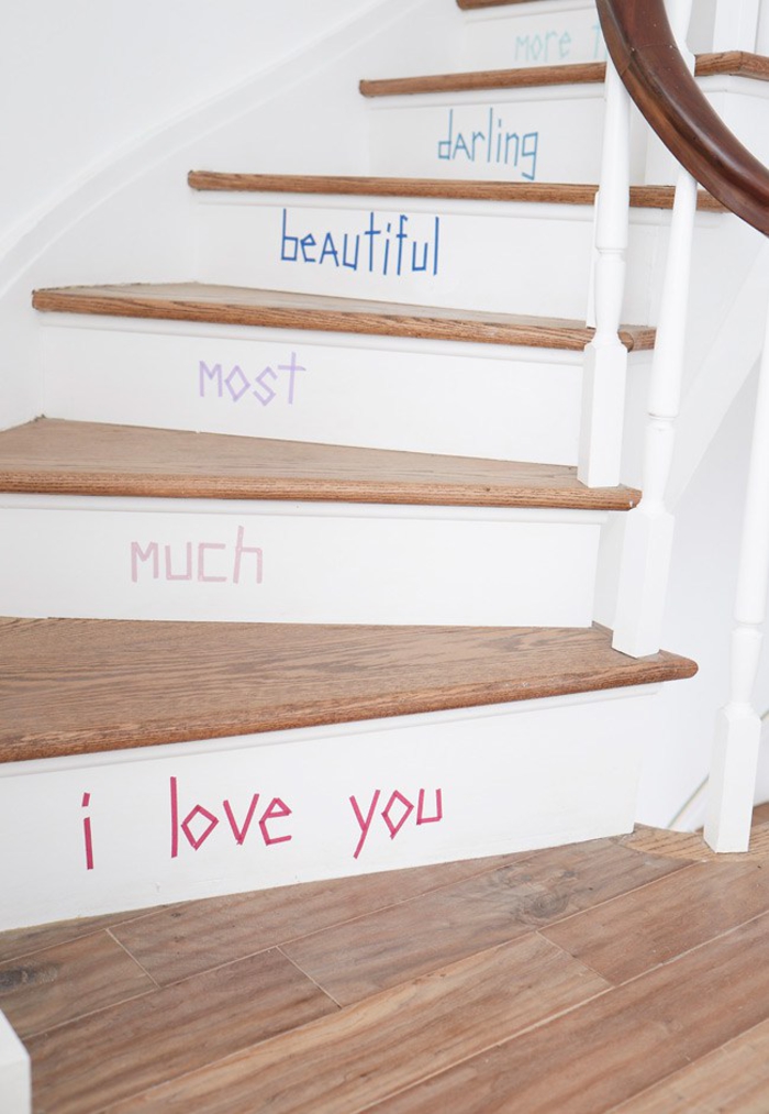 astuces déco pour renover un escalier en bois avec un petit budget, des contre-marches repeintes en blanc portant un message réalisé au masking tape