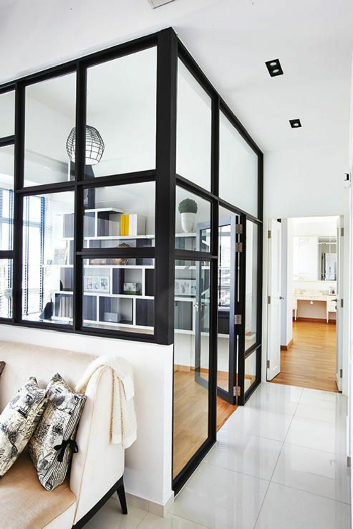 séparation chambre salon, en métal noir avec des vitres blanches transparentes, dalles blanches, parquet en PVC
