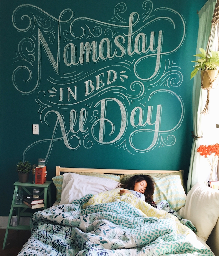 exemple d amenagement chambre avec lit en bois, linge de lit exotique à motifs floraux, et mur de fond en peinture à la craie, chambre cocooning