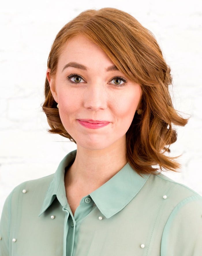 exemple-de-coiffure-carré-plongeant-sur-le-coté-avec-des-ondulations-cheveux-couleur-rousse-tirant-vers-le-blond exemple de coiffure carré plongeant style long avec frange sur le coté, chemise femme vert clair