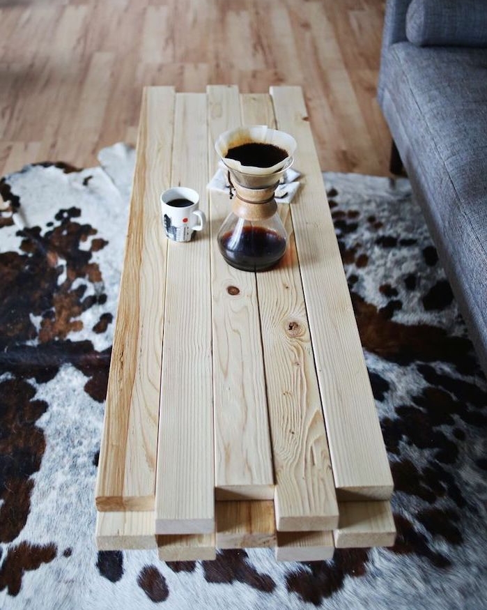 fabriquer une table basse en lattes de bois blond, tapis peau animale, canapé gris, parquet clair