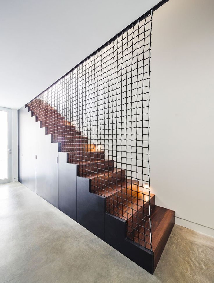 cage d'escalier au design contemporain et aux lignes épurées entièrement en bois avec un garde-corps filet métallique