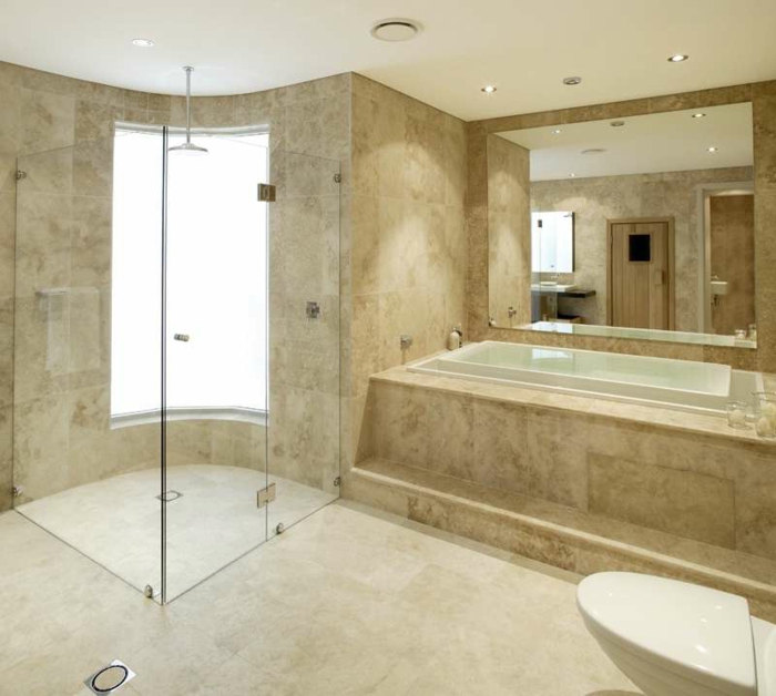 petite espace de douche, grande baignoire, grand miroir mural, salle de bain travertine