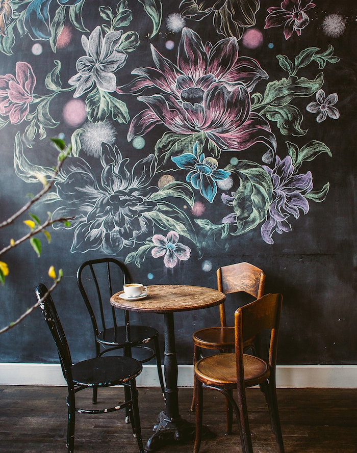 dessin de fleurs sur les murs d un café, fleurs colorées à la craie, parquet marron foncé, table et chaises en bois et métal style industriel