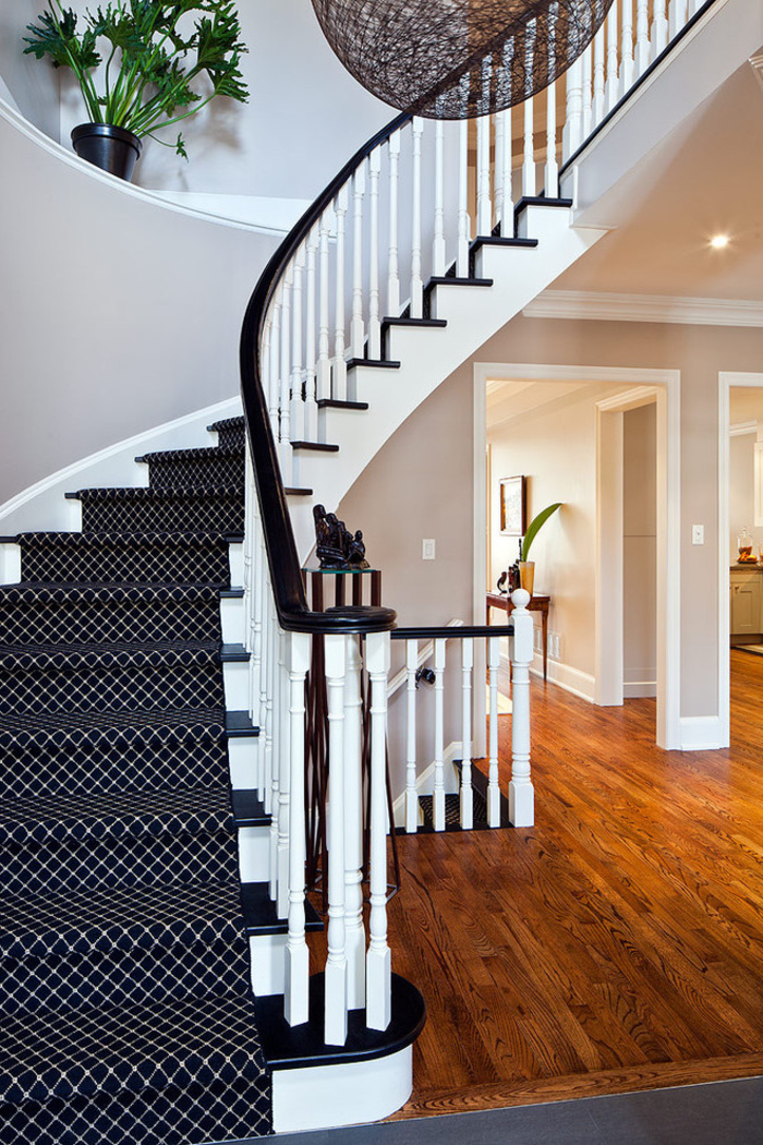 escalier repeint en blanc et noir aux marches et aux contre-marches contrastantes, revêtu de tapis à motif graphique 