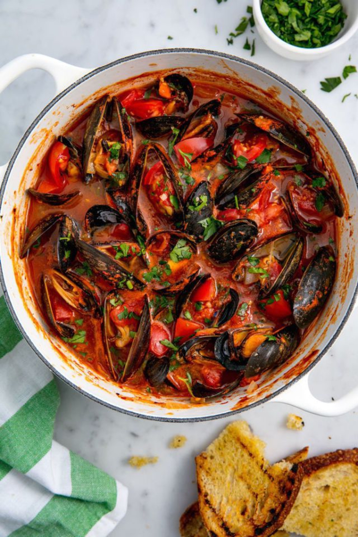 un menu st valentin inspiré de la cuisine méditerranéenne, plat principal de moules cuites à la vapeur à la sauce tomate