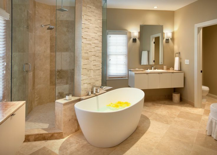 idée déco salle de bain avec travertin, baignoire en jolie forme ovale, petit miroir suspendu, espace douche