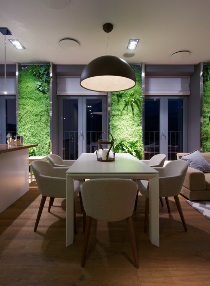 jardin vertical, lampe suspendue noire, murs en mousse verte, table blanche et chaises blanches
