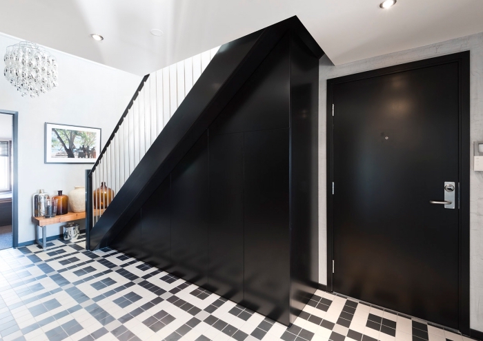 design stylé en blanc et noir avec escalier moderne noir et rangement sous pente en meubles sans poignées