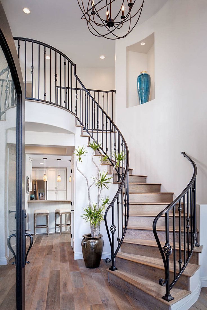 idée pour une deco montee escalier de style méditerranéen avec jolie rambarde de fer forgé et un luminaire en suspension en fils de fer