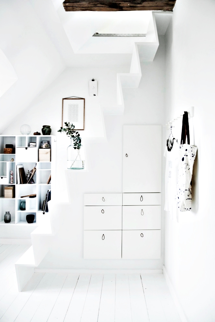 couloir blanc avec petit escalier minimaliste et rangement sous pente en armoires blanches