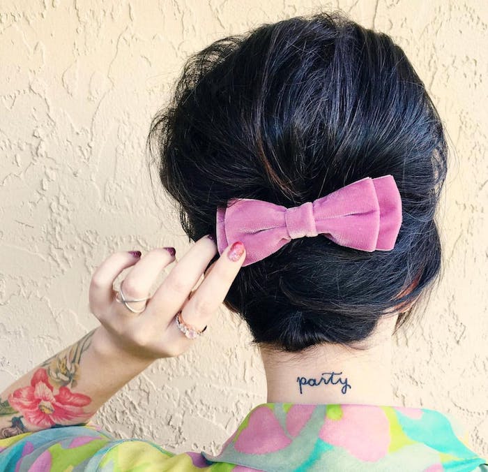 modele-de-cheveux-attahcés-derrière-avec-un-noeud-de-ruban-rose-robe-colorée cheveux femme attachés en arrière avec un noeud de ruban rose, exemple coiffure carré plongeant