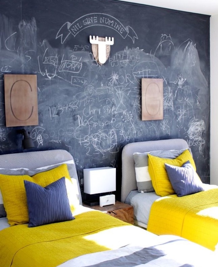 exemple de déco chambre enfant double avec des lits gris et linge de lit gris et blanc, mur en ardoise murale avec des gribouillis