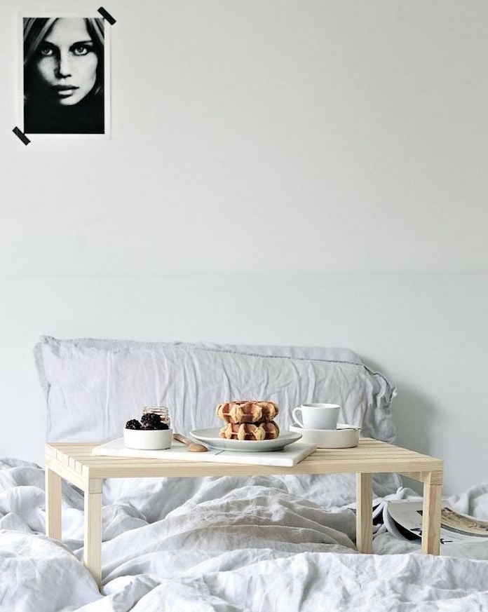 exemple de table basse diy de lit en lattes de bois clair sur un linge de lit gris, deco murale portrait noir et blanc femme