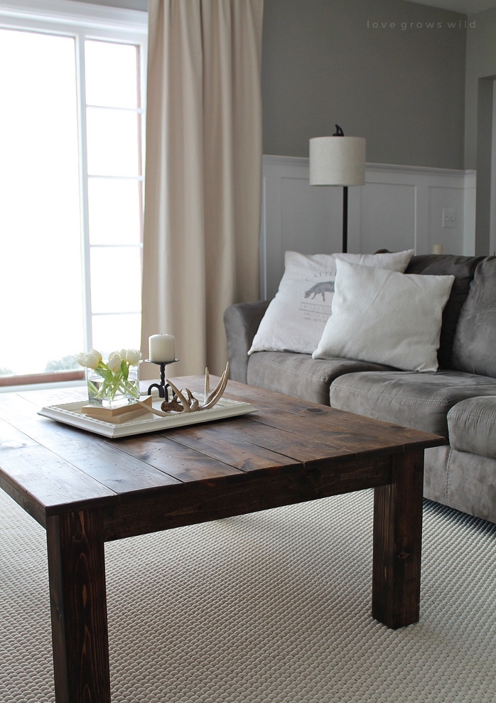 table basse diy en planches de bois avec tapis blanc cassé, canapé gris et coussins blancs, style traditionnel