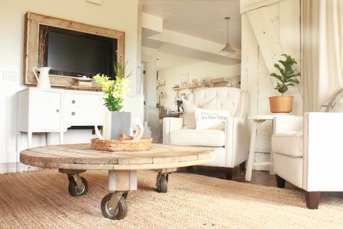 modele de table basse touret en plateau de bois sur roulettes, tapis beige, fauteuils blancs, deco style campagne rustique