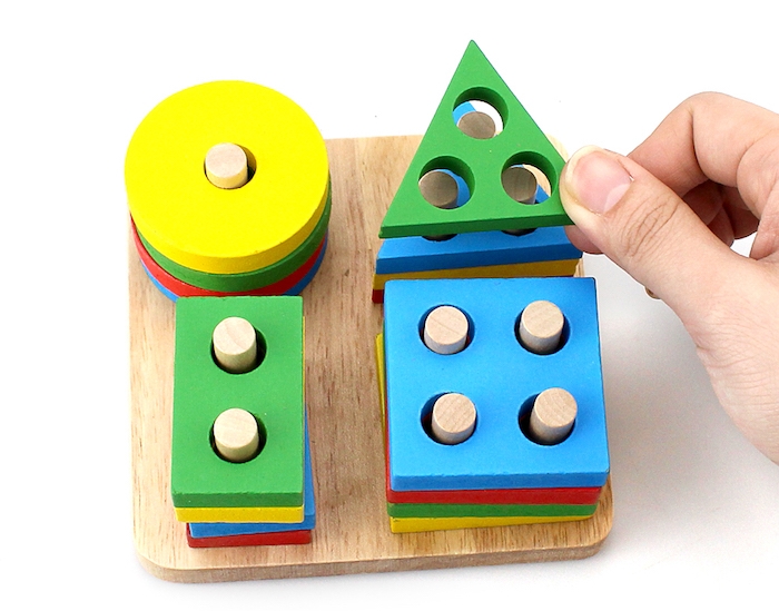 jeu d association, rangement de figures geometriques colorées sur une planche en bois, pédagogie montessori en crèche