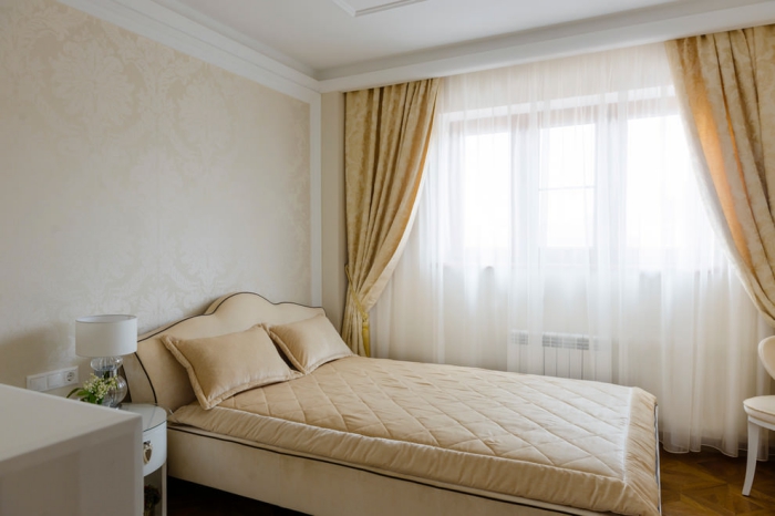 aménagement simple dans la chambre à coucher avec rideaux jaune et meubles de cuir beige