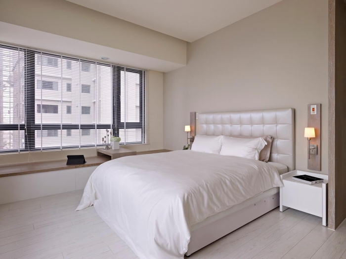 chambre design moderne avec lit kingsize de tête boutonnée, déco minimaliste avec lit et banc de bois sous fenetre