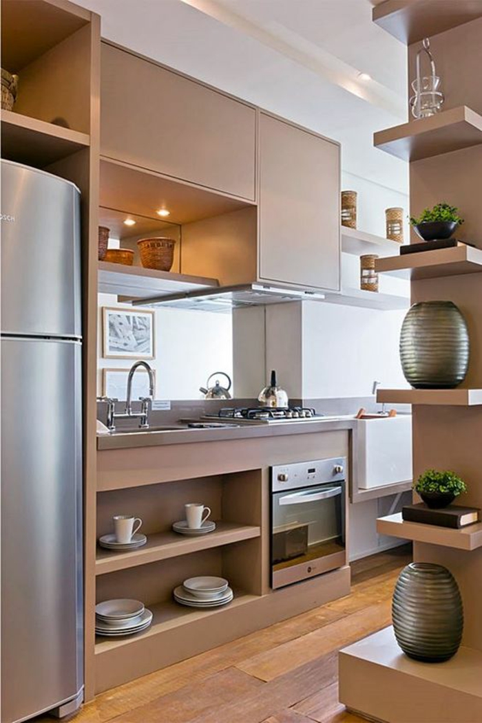 meubles de cuisine, petite cuisine équipée, cuisine petit espace, avec plein d’étagères au mur, sol recouvert de parquet en nuances marron et jaune, frigo haut et large dans une niche 