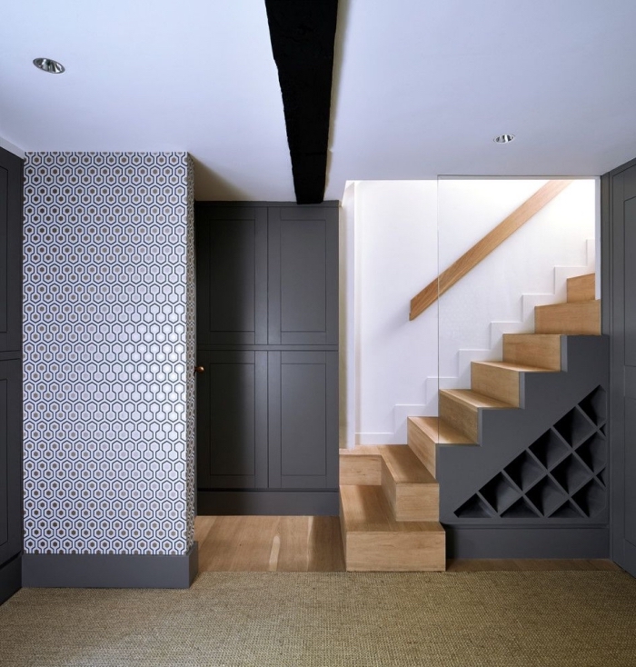 décoration intérieur en blanc noir et bois avec escalier moderne et rangement sous pentes pour bouteilles ou chaussures