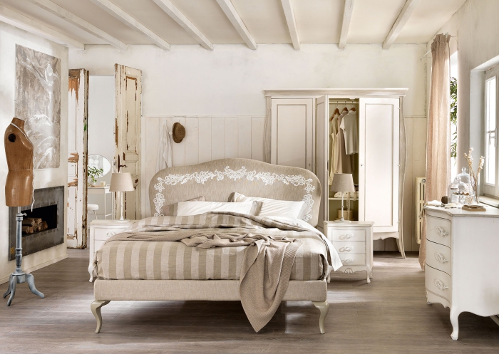 chambre adulte aux murs blancs avec meubles repeints de style shabby chic et cheminée beton