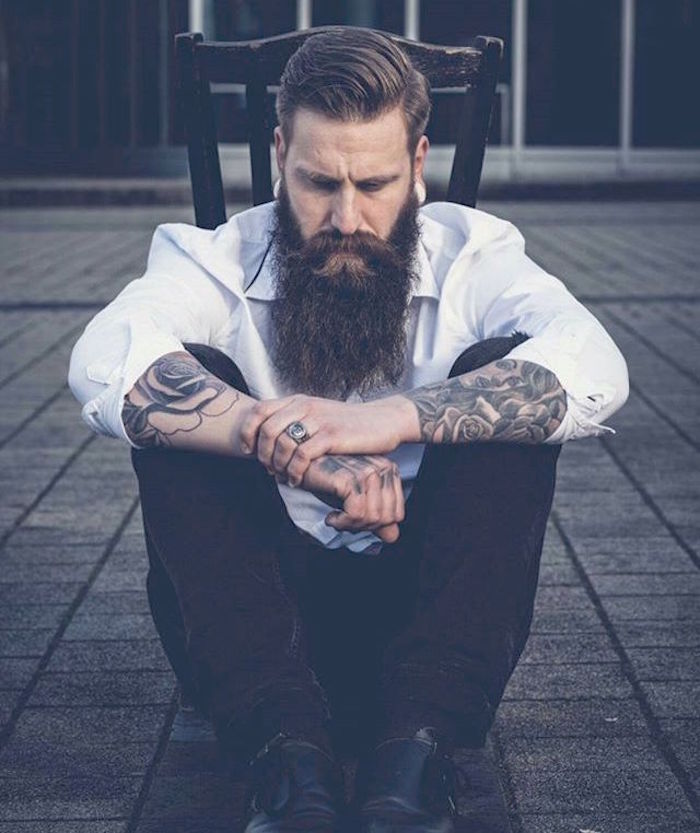 look hipster homme avec coiffure dégradé et tattoo old school et grande barbe