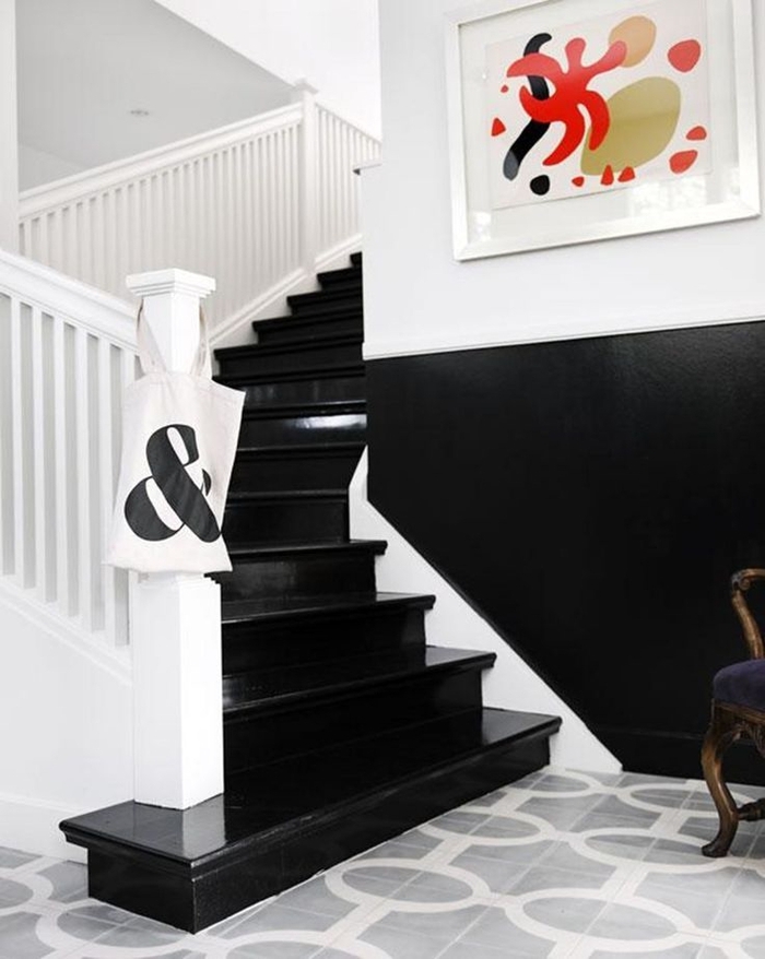 cage d'escalier en noir et blanc qui joue sur l'effet de contraste entre les marches et le soubassement noirs et la rambarde blanche