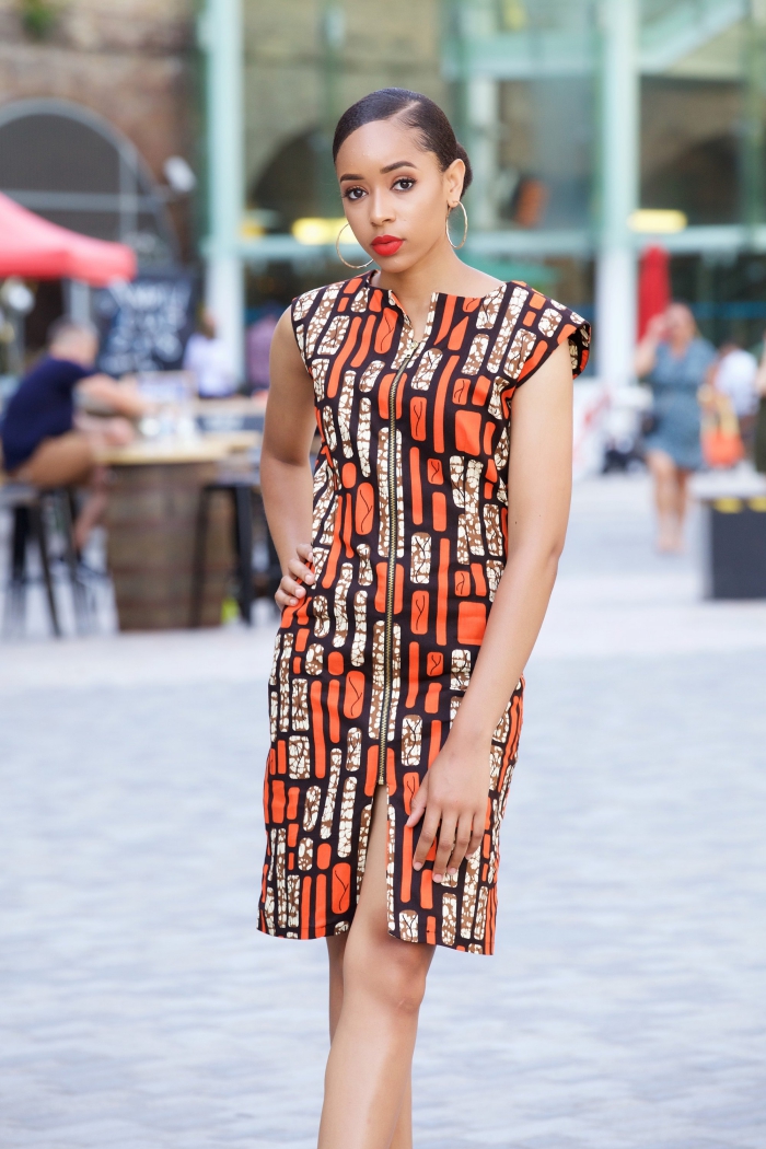 mode femme africaine moderne avec robe mi-longue en orange et noir, modèle de robe longueur genoux avec fente