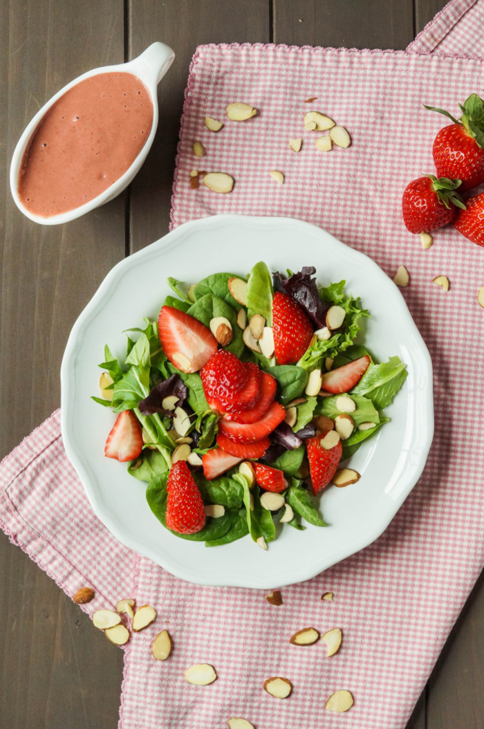 une salade verte aux fraises et aux amandes avec une vinaigrette à la fraise pour commencer en toute légèreté votre repas de saint valentin